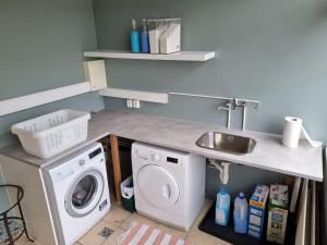 a kitchen with a sink and a washing machine at The Northern Comfort Inn in Ólafsfjörður +21 photos