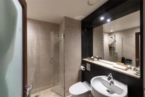 a bathroom with a toilet and a sink and a shower at Apex City of Edinburgh Hotel in Edinburgh