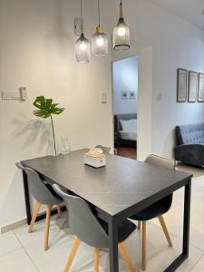 una mesa de comedor negra con sillas y una sala de estar. en REIZZ RESIDENCE BY BERJAYA, en Kuala Lumpur