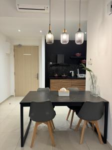 a dining room with a black table and chairs at REIZZ RESIDENCE BY BERJAYA in Kuala Lumpur