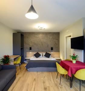 ein Schlafzimmer mit einem Bett, einem Sofa und einem Tisch in der Unterkunft B&B Dimora Morelli in Gubbio