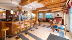 a restaurant with a bar and tables and chairs at Familien-Sporthotel Florianihof in Sankt Kanzian