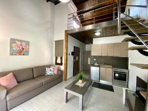 Aelia Studios في سكالا بوتامياس: غرفة معيشة مع أريكة ودرج حلزوني