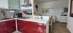een keuken met rode kasten en een wit aanrecht bij Residenza Ca' Margherita Noale Venezia in Noale