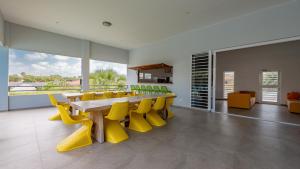 a dining room with a table and yellow chairs at Residence Selavi Curacao in Jan Thiel