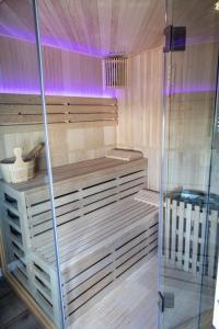 een sauna met een glazen douche en paarse verlichting bij Le Street in Calais