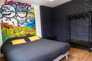 1 dormitorio con 1 cama con una pintura en la pared en Le Street en Calais