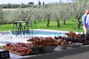 a buffet of food on a table next to a pool at La Cipressina B&B in Cavaion Veronese
