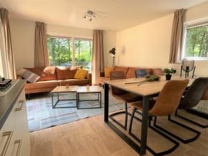 a kitchen and living room with a table and a couch at Vakantiepark Hertenhorst in Beekbergen