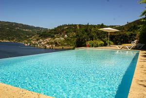 - une grande piscine avec vue sur l'eau dans l'établissement Casa da Torre, Porto Manso, à Ribadouro