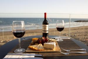 a table with a plate of food and two glasses of wine at Don Gregory by Dunas - Adults Only in San Agustin