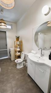 een badkamer met een toilet, een wastafel en een spiegel bij cala sun villa קאלה סאן וילה in Kefar HaRif
