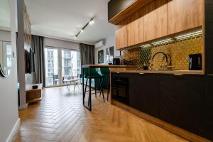 a kitchen with a counter and a dining room at Stary Browar Apartamenty in Bielsko-Biała