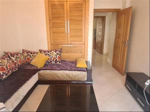 a living room with a couch with pillows on it at Agadir, Simple mais confortable in Agadir