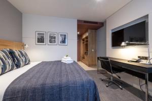 a bedroom with a bed and a desk and a television at Apex City of Edinburgh Hotel in Edinburgh