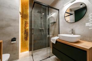 een badkamer met een wastafel en een douche bij Stary Browar Apartamenty in Bielsko-Biala +18 foto's