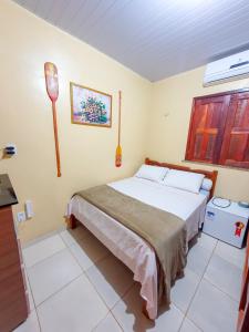 a bedroom with a bed and a window at Babylon Village in Algodoal