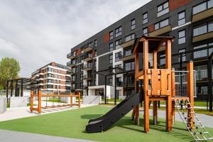 een speeltuin met een glijbaan voor een gebouw bij Stary Browar Apartamenty in Bielsko-Biala