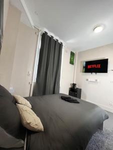 ein Schlafzimmer mit einem Bett mit einer Uhr an der Wand in der Unterkunft Nuit d'amour in Ermont