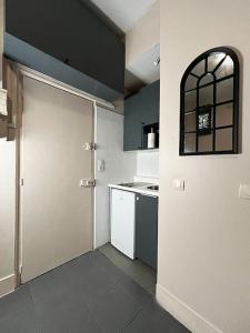 eine große weiße Küche mit einer Tür und einer Theke in der Unterkunft Nuit d'amour in Ermont