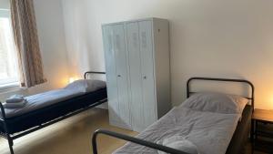 1 dormitorio con 2 camas y armario blanco en A2rooms, en Lehnin