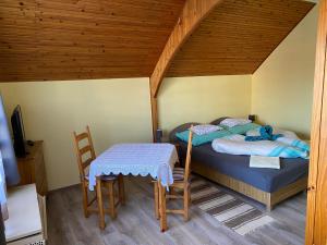 Schlafzimmer mit einem Bett, einem Tisch und Stühlen in der Unterkunft Aranypatak Apartmanház Hévíz in Hévíz