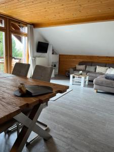 - un salon avec une table en bois et un canapé dans l'établissement Ferienwohnung Buchenblick, à Monschau