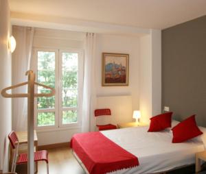 Un dormitorio con una cama con almohadas rojas y una ventana en Apartamento Labegain 1, en Sestao