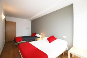 een slaapkamer met 2 bedden en rode kussens bij Apartamento Labegain 1 in Sestao