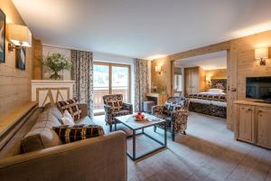 a living room with a couch and chairs and a bed at Hotel Auenhof in Lech am Arlberg