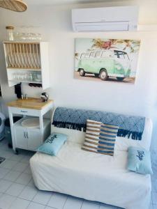 d'un salon avec un canapé blanc et une peinture murale sur van. dans l'établissement Magnifique T2 - Le Lagon bleu, au Grau-du-Roi