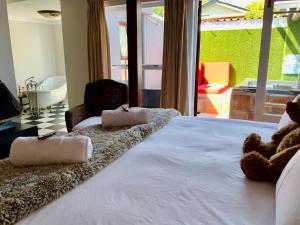 a bedroom with a large white bed with two towels on it at Goblin's Creek in St Helena Bay