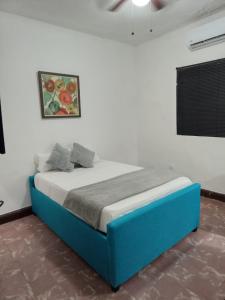 1 dormitorio con 1 cama azul en una pared blanca en Confortable Loft MN 960 F Centro, en Monterrey