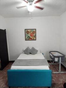 1 dormitorio con 1 cama azul y ventilador de techo en Confortable Loft MN 960 F Centro, en Monterrey
