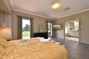 a bedroom with a large bed and a large window at The Residence - Ironstone Estate Hunter Valley in Lovedale