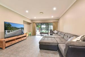 a living room with a couch and a flat screen tv at The Residence - Ironstone Estate Hunter Valley in Lovedale