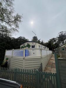 een wit hek met een huis erachter bij HOLIDAY PARK HOUSE in Hastings