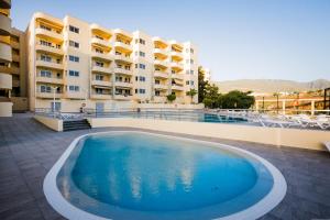 a large swimming pool in front of a building at 422 Quiet, beautiful flat with sea view in Playa Paraiso +32 photos