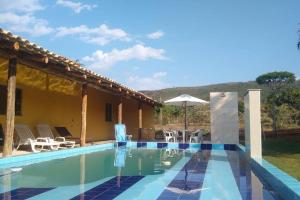 a villa with a swimming pool and a house at Sítio Paraíso Serrano em Igarapé in Igarapé