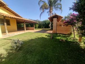 a backyard of a house with a grass yard at Sítio Paraíso Serrano em Igarapé in Igarapé