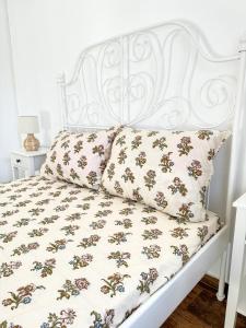 - un lit blanc avec une tête de lit et des oreillers blancs dans l'établissement Апартамент за гости Лена Златоград, à Zlatograd