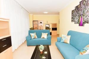 a living room with two blue chairs and a table at VT Entre dous mares in Finisterre