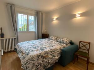 a bedroom with a bed and a chair and a window at AUBER Modern big apartment with Parking 12 minutes from Metro in Vitry-sur-Seine
