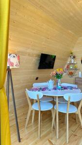 a dining room with a table and chairs and a tv at Magical space Tsikhisdziri in Tsikhisdziri