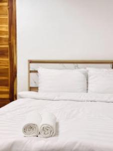 dos toallas están sentadas en una cama blanca en Chubby 5 Room 4 en Ban Bang Bamru