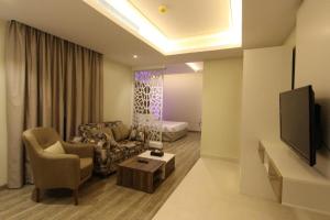 sala de estar con sofá y TV en حياة روز للشقق الفندقية, en Riad
