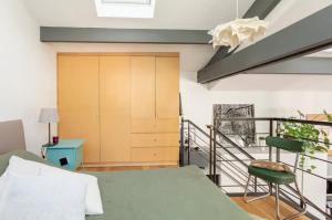um quarto com uma cama verde e uma porta de madeira em Cosy loft in Courbevoie em Courbevoie