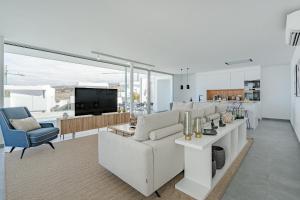 Una sala de estar con un sofá blanco y una cocina. en Villa Estándar 1 - Casangular by Upper, en Adeje