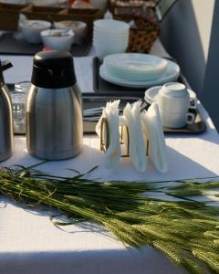 una mesa con platos y utensilios y cebolla verde en La Familia Luxury Private Maisonettes near sea, en Gythio