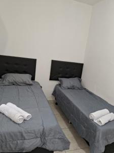 dos camas sentadas una al lado de la otra en un dormitorio en Casa espaçosa em Belo Horizonte, en Belo Horizonte